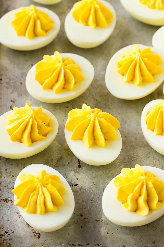 Bacon Deviled Eggs | Deviled Eggs Recipe #eggs #keto #lowcarb #bacon #appetizer #jonep Deviled eggs with a decoratively piped filling on a sheet pan.