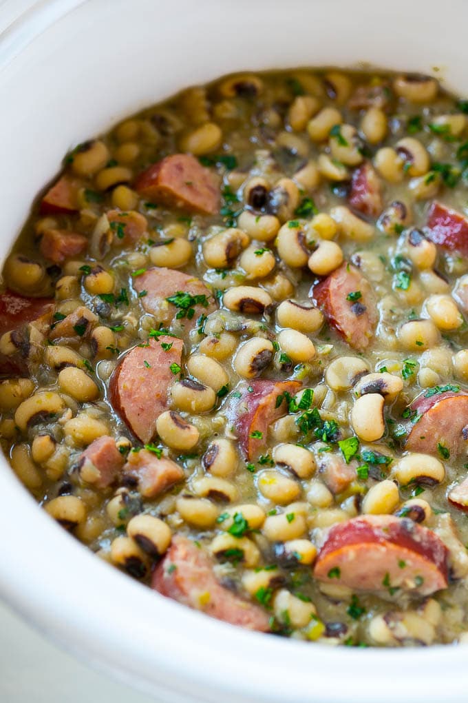 Slow Cooker Black Eyed Peas Recipe | Crock Pot Black Eyed Peas | Southern Black Eyed Peas | Black Eyed Peas with Ham | Black Eyed Peas with Sausage #blackeyedpeas #slowcooker #crockpot #sausage #newyears #dinner #jonep These crock pot black eyed peas with sausage and ham are the perfect meal for new years.