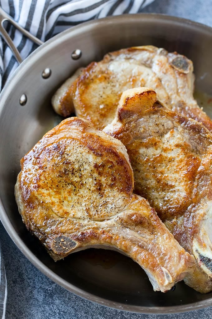 Brown Sugar Pork Chops Recipe | Bone In Pork Chops Recipe | Garlic Butter Pork Chops | Skillet Pork Chops #pork #porkchops #garlic #dinner #glutenfree #jonep Browned bone in pork chops in a frying pan.