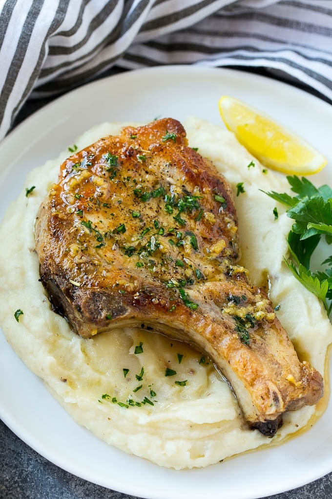 Brown Sugar Pork Chops Recipe | Bone In Pork Chops Recipe | Garlic Butter Pork Chops | Skillet Pork Chops #pork #porkchops #garlic #dinner #glutenfree #jonep Brown sugar pork chops on a bed of mashed potatoes.