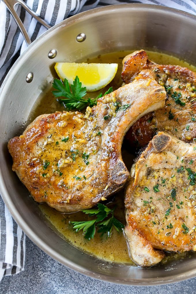 Brown Sugar Pork Chops Recipe | Bone In Pork Chops Recipe | Garlic Butter Pork Chops | Skillet Pork Chops #pork #porkchops #garlic #dinner #glutenfree #jonep Brown sugar pork chops with garlic, butter and herbs in a frying pan.