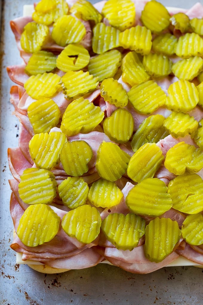 Cuban Sliders Recipe | Cuban Sandwich Recipe | Slider Sandwiches | Ham and Cheese Sliders #sliders #sandwiches #ham #cheese #appetizer #jonep Bread layered with cheese, ham and pickles.