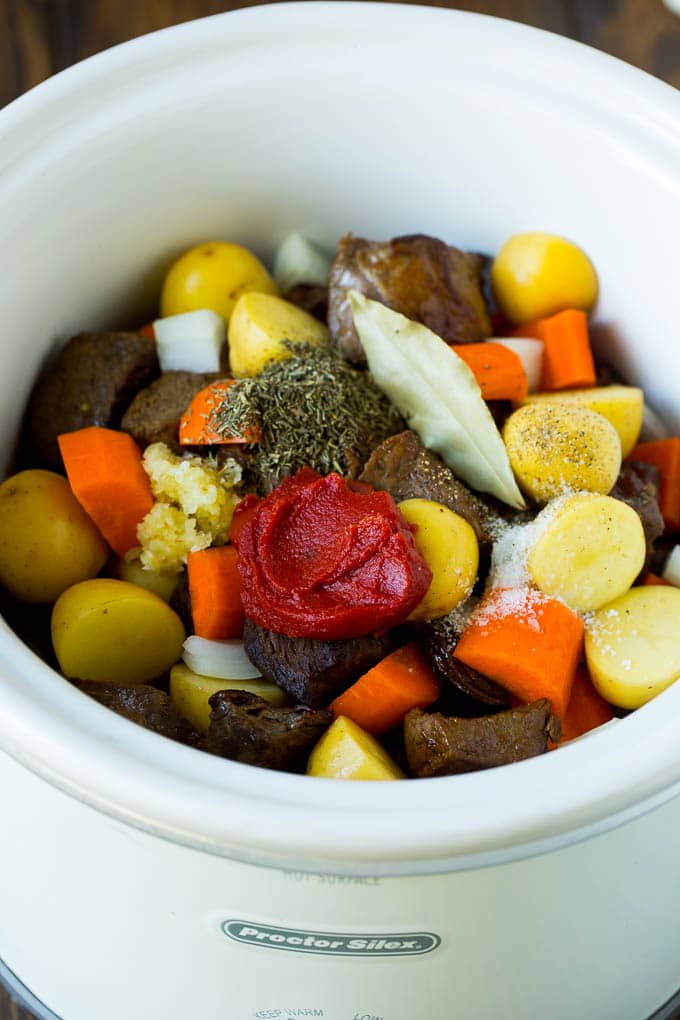 Slow Cooker Beef Stew Recipe | Crockpot Beef Stew #stew #soup #beef #slowcooker #crockpot #dinner #jonep A crock pot filled with beef, vegetables, tomato paste, herbs and spices.