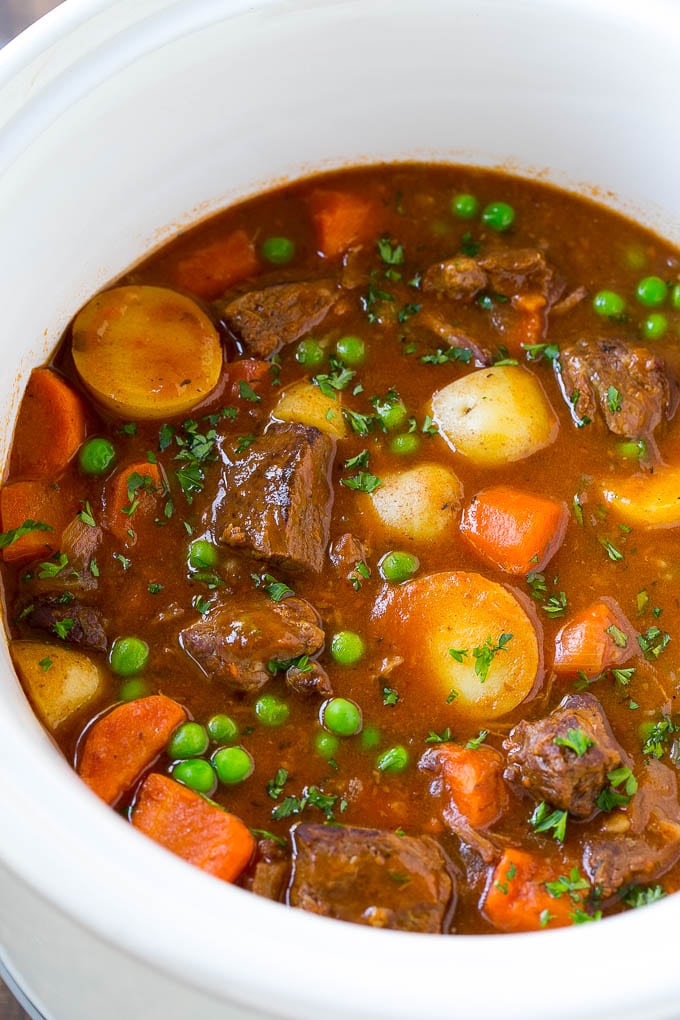Slow Cooker Beef Stew Recipe | Beef and Potato Stew | Crock Pot Beef Stew | Easy Beef Stew #beef #beefstew #soup #slowcooker #crockpot #dinner #jonep A slow cooker full of beef stew that contains meat, potatoes, carrots and peas, all in a savory broth.