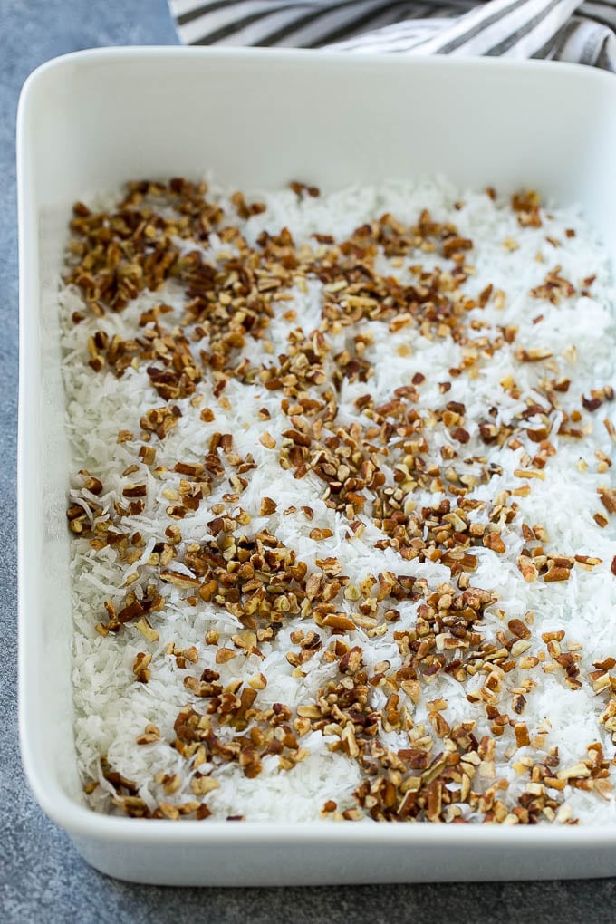 Earthquake Cake Recipe | Chocolate Cake Recipe | Chocolate Coconut Cake | Coconut Pecan Cake #cake #chocolate #coconut #pecans #dessert #chocolatecake #jonep Coconut and pecans layered into a cake pan.