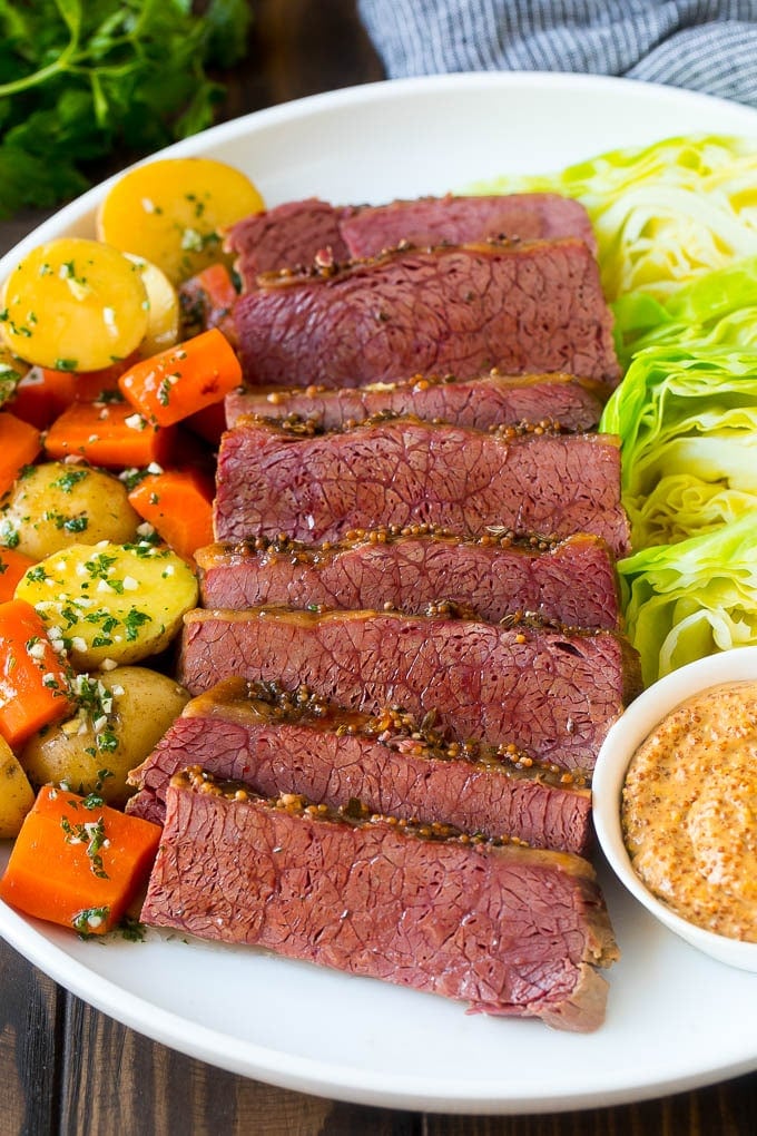 Slow Cooker Corned Beef Recipe | Crock Pot Corned Beef | Corned Beef and Cabbage #beef #cornedbeef #cabbage #potatoes #carrots #stpatricksday #irish #jonep A platter of slow cooker corned beef, cabbage wedges, potatoes and carrots.