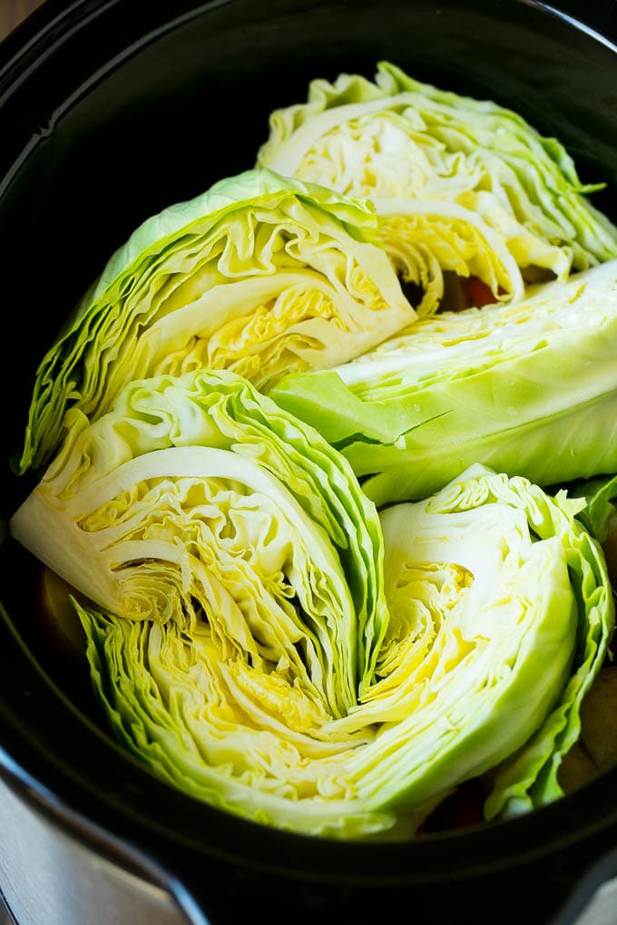 Slow Cooker Corned Beef Recipe | Crock Pot Corned Beef | Corned Beef and Cabbage #beef #cornedbeef #cabbage #potatoes #carrots #stpatricksday #irish #jonep Cabbage wedges inside a crock pot.