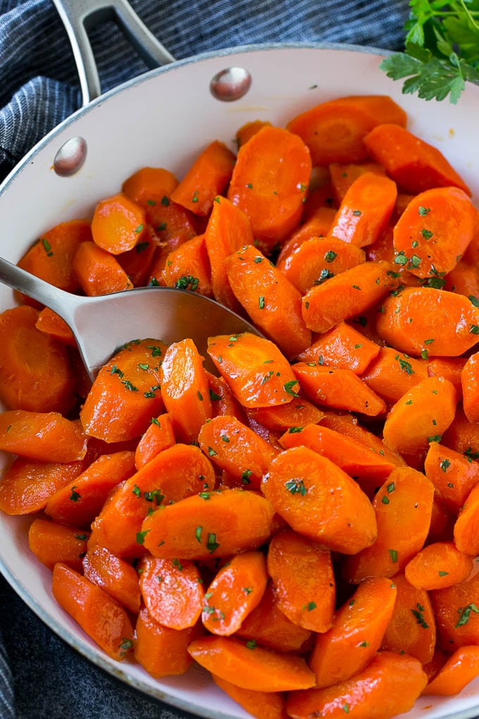 Candied Carrots Recipe | Carrot Side Dish | Brown Sugar Carrots | Glazed Carrots #carrots #brownsugar #sidedish #dinner #jonep Candied carrots in a pan with a serving spoon.