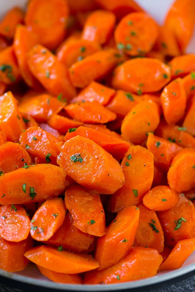 Candied Carrots Recipe | Carrot Side Dish | Brown Sugar Carrots | Glazed Carrots #carrots #brownsugar #sidedish #dinner #jonep A close up of cooked candied carrots topped with parsley.