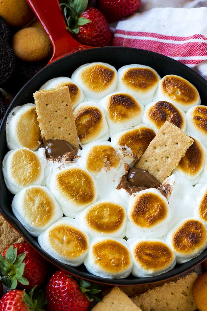 S'mores Dip Recipe | S'mores Skillet | Baked S'mores #smores #dip #chocolate #marshmallow #dessert #jonep A skillet of s'mores dip with melted milk chocolate topped with toasted marshmallows.