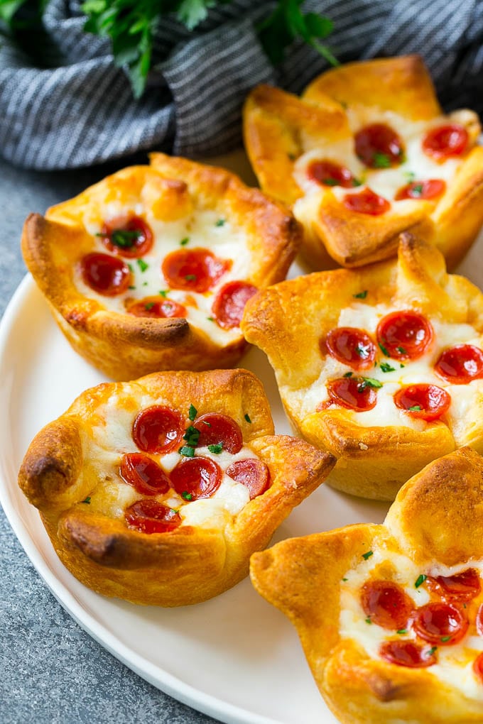 Pizza Muffins Recipe | Pizza Bites | Pizza Cups | Pizza Appetizer #pizza #appetizer #jonep A plate of pizza muffins made with crescent roll dough, pizza sauce, melted cheese and mini pepperoni.