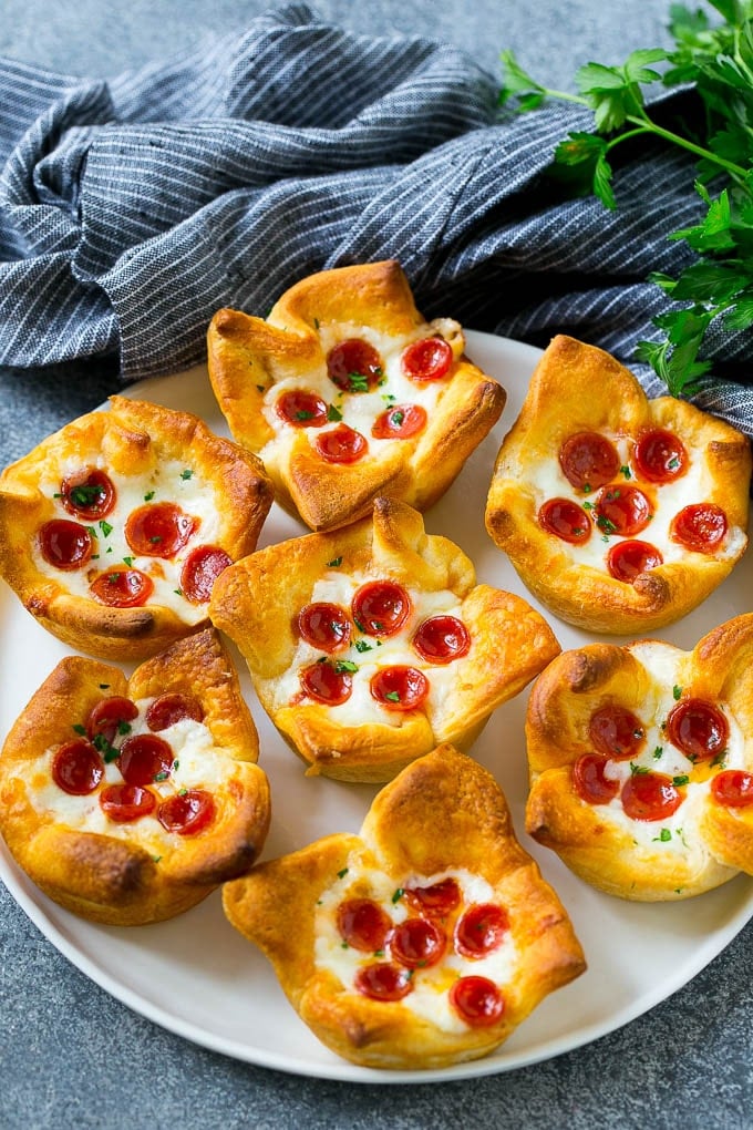 Pizza Muffins Recipe | Pizza Bites | Pizza Cups | Pizza Appetizer #pizza #appetizer #jonep Pizza muffins on a serving plate garnished with parsley.