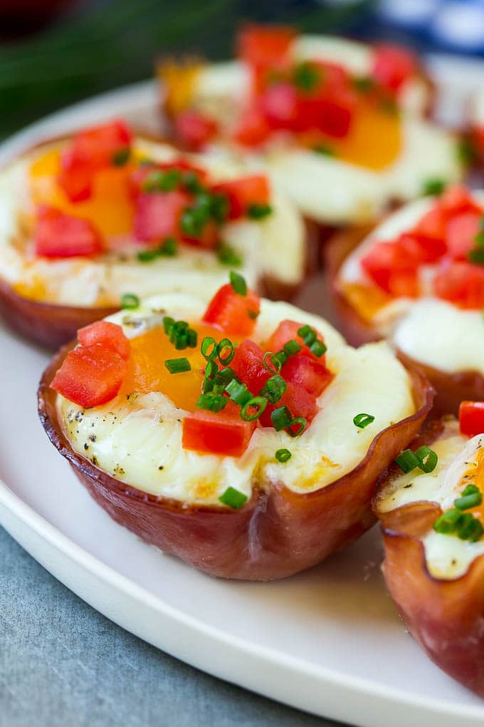 Ham and Egg Cups Recipe | Low Carb Breakfast | Ham and Eggs #ham #eggs #lowcarb #breakfast #jonep A plate of ham and egg cups topped with diced tomatoes and chives.