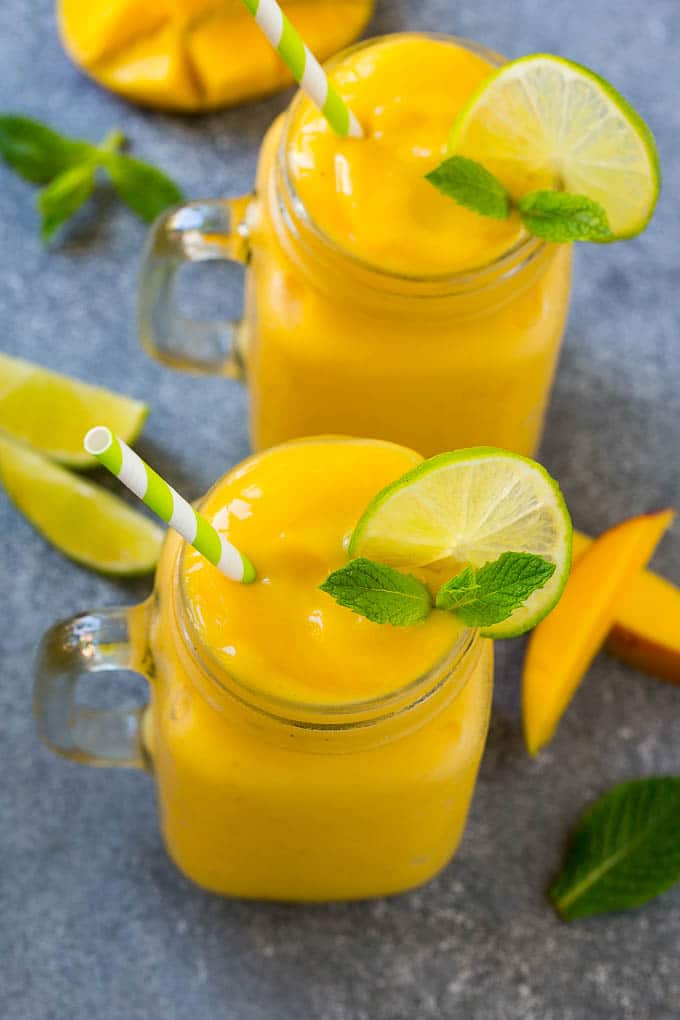 Mango Smoothie Recipe | Mango Recipe | Healthy Smoothie #mango #smoothie #drink #jonep Two jars full of mango smoothie, garnished with lime slices and fresh mint.
