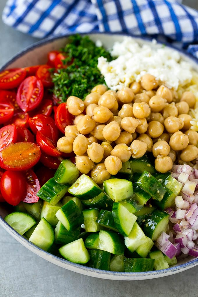 Orzo Salad Recipe | Orzo Pasta Salad | Greek Orzo Salad | Mediterranean Orzo Salad #pastasalad #orzo #greekfood #salad #jonep A bowl of orzo pasta, tomatoes, cucumbers, red onions, chickpeas and feta cheese topped with dressing.