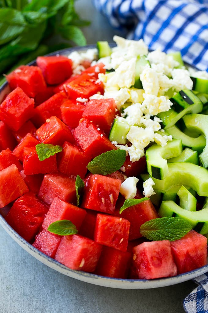 Watermelon Salad Recipe | Watermelon Feta Salad | Watermelon Cucumber Salad #watermelon #cucumber #salad #jonep A bowl of watermelon, cucumber, feta cheese and mint leaves drizzled with lime dressing.