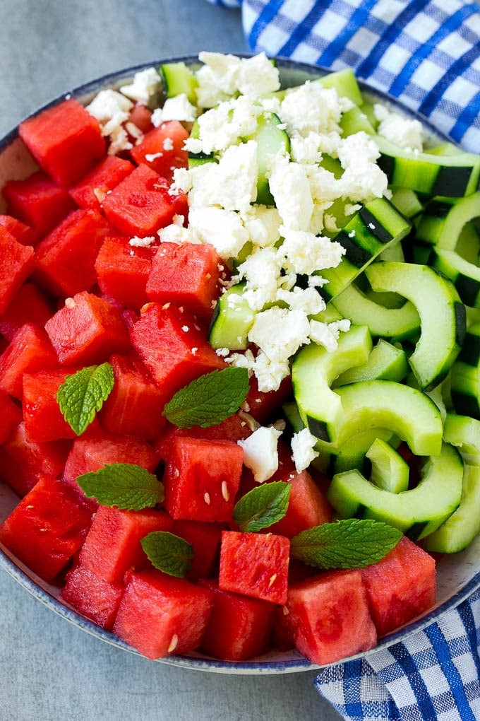 Watermelon Salad Recipe | Watermelon Feta Salad | Watermelon Cucumber Salad #watermelon #cucumber #salad #jonep A bowl of cubed watermelon, sliced cucumbers, feta cheese and mint leaves.