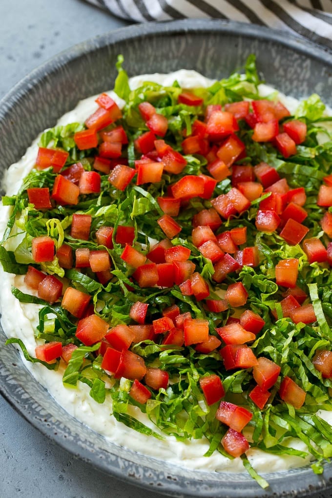 BLT Dip Recipe | Bacon Dip Recipe | Ranch Dip #dip #ranch #bacon #lettuce #tomato #appetizer #jonep Lettuce and tomatoes on top of ranch dip.