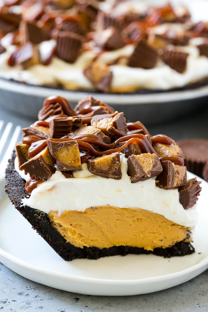 Chocolate Peanut Butter Pie Recipe | Peanut Butter Cup Pie | Peanut Butter Pie | No Bake Pie #chocolate #peanutbutter #pie #nobake #dessert #jonep A slice of chocolate peanut butter pie topped with whipped cream, chocolate sauce and peanut butter cups.