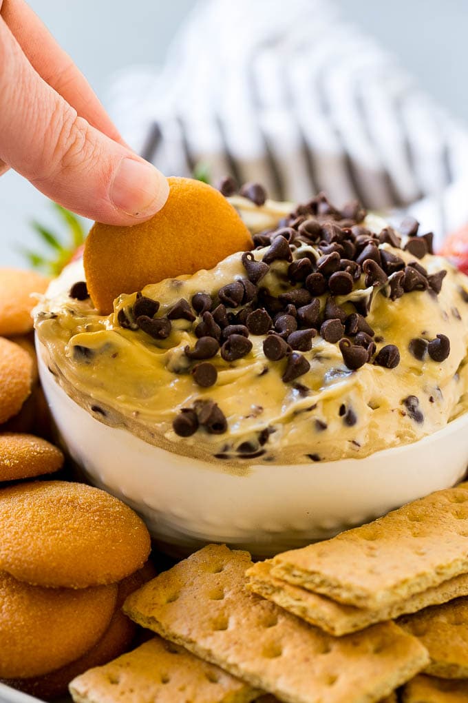 Cookie Dough Dip Recipe | Edible Cookie Dough | Chocolate Chip Cookie Dip #cookies #dip #cookiedough #dessert #snack #jonep A cookie scooping into a bowl of dip.