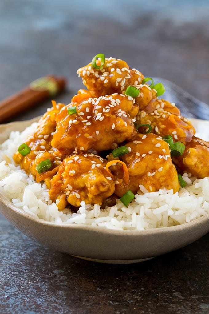 Orange Chicken Recipe | Chinese Orange Chicken | Panda Express Orange Chicken #orange #chicken #takeout #chinesefood #dinner #jonep A bowl of orange chicken served over steamed rice and topped with sesame seeds.