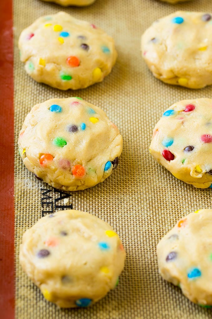 Oreo Stuffed Cookies Recipe | M&M's cookies | Stuffed Cookies #cookies #chocolate #oreos #dessert #baking #jonep Cookie dough balls stuffed with Oreo cookies on a sheet pan.
