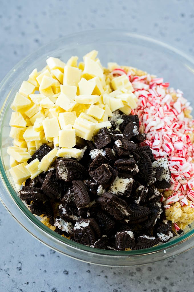 Oreo Peppermint Cookies Recipe | Candy Cane Cookies | Oreo Cookies #oreo #peppermint #cookies #baking #Christmas #sweets #jonep A bowl of dough with Oreo pieces, white chocolate chunks and crushed candy canes.