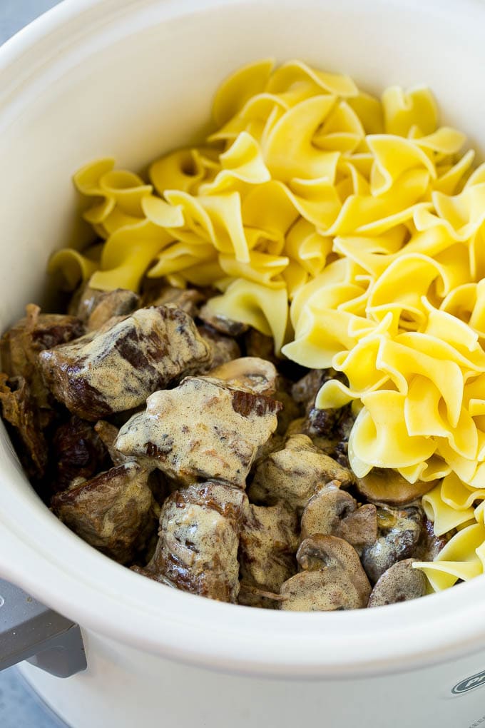 Slow Cooker Beef Stroganoff Recipe | Crock Pot Beef Stroganoff | Beef Recipe #slowcooker #crockpot #beef #mushrooms #pasta #dinner #jonep Beef in a creamy sauce and egg noodles in a slow cooker.