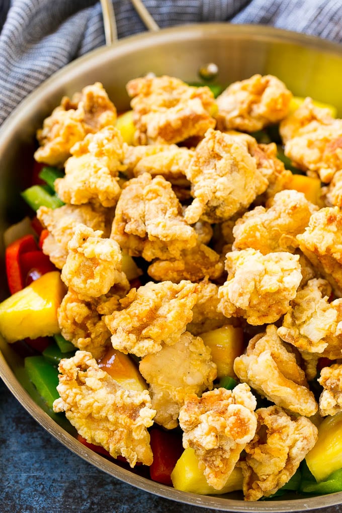 Sweet and Sour Chicken Recipe | Chinese Food Copycat Recipe | Chicken with Pineapple #chicken #chinesefood #pineapple #stirfry #takeout #dinner #jonep Fried chicken pieces in a pan with pineapple, peppers and onions.