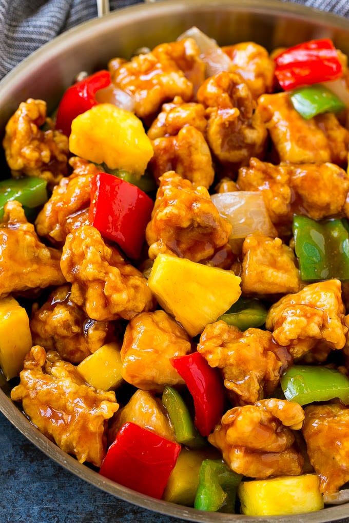 Sweet and Sour Chicken Recipe | Chinese Food Copycat Recipe | Chicken with Pineapple #chicken #chinesefood #pineapple #stirfry #takeout #dinner #jonep A frying pan of sweet and sour chicken with crispy chicken, pineapple, bell peppers and onions.