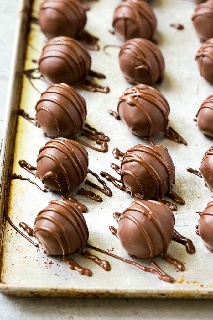 Chocolate Covered Cherries Recipe | Cherry Cordials | Cherry Candy #chocolate #candy #dessert #cherry #sweets #jonep Chocolate covered cherries on a sheet pan with a chocolate drizzle on top.