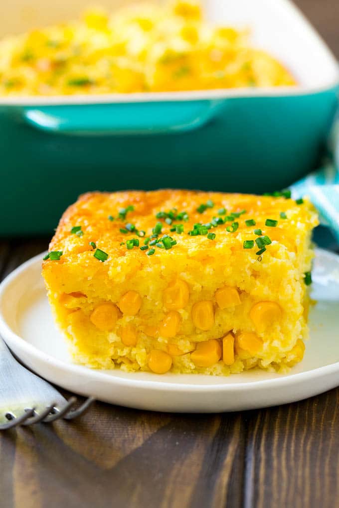 Corn Pudding Recipe | Corn Casserole | Corn Side Dish #corn #pudding #casserole #sidedish #thanksgiving #dinner #jonep A serving of corn pudding on a plate, garnished with chives.