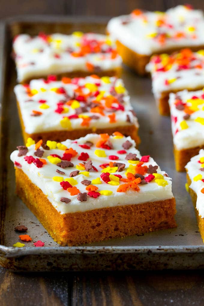 Pumpkin Bars Recipe | Pumpkin Cake | Pumpkin Dessert #pumpkin #fall #dessert #jonep #thanksgiving A baking sheet of frosted pumpkin bars.