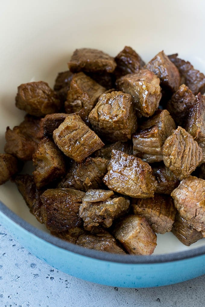 Seared stew meat in a large pot.