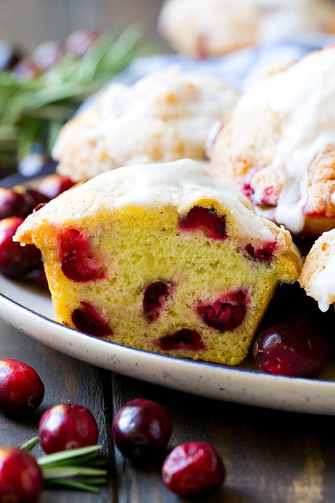Cranberry Muffins Recipe | Cranberry Orange Muffins #cranberry #muffins #orange #fall #dessert #jonep A plate of muffins with one cut in half.
