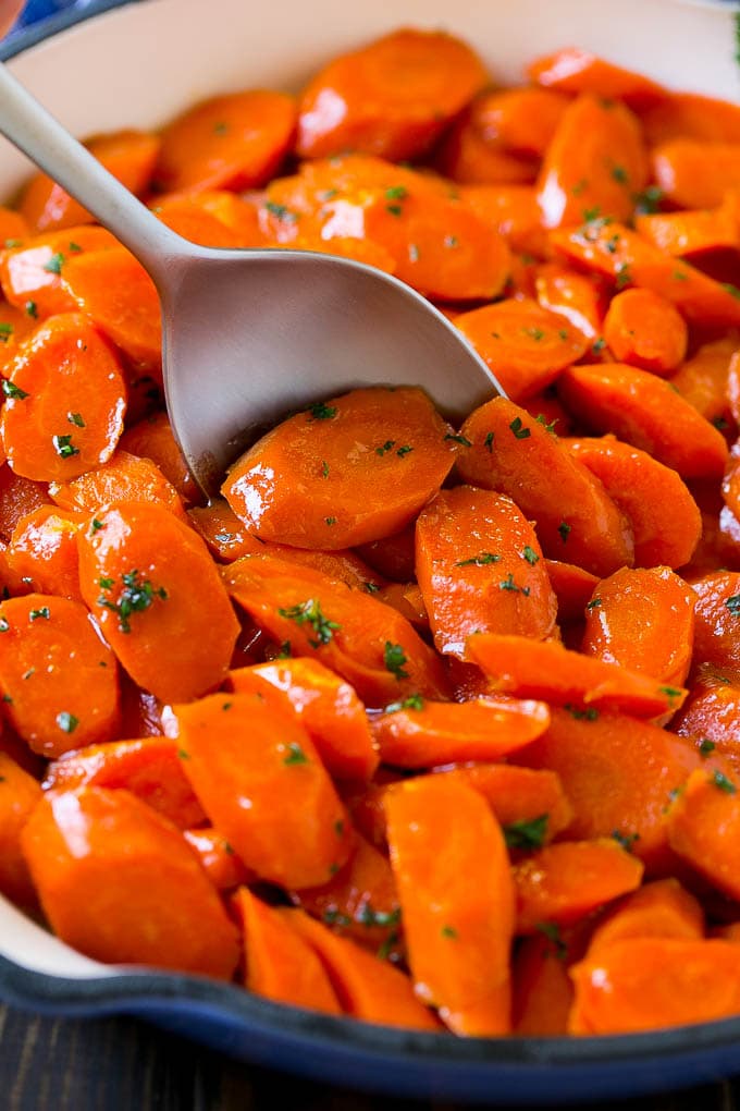 Glazed Carrots Recipe | Brown Sugar Carrots | Carrot Side Dish #carrots #brownsugar #sidedish #glutenfree #thanksgiving #fall #dinner #jonep Glazed carrots in a skillet with a serving spoon.