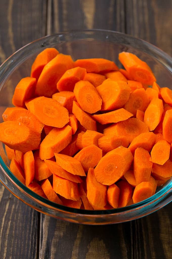 Glazed Carrots Recipe | Brown Sugar Carrots | Carrot Side Dish #carrots #brownsugar #sidedish #glutenfree #thanksgiving #fall #dinner #jonep A bowl of peeled and sliced carrots.
