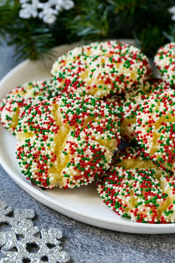Gooey Butter Cookies Recipe | Cake Mix Cookies | Sprinkle Cookies | Christmas Cookies #cookies #butter #sprinkles #christmas #dessert #baking #jonep A plate of gooey butter cookies covered in holiday sprinkles.