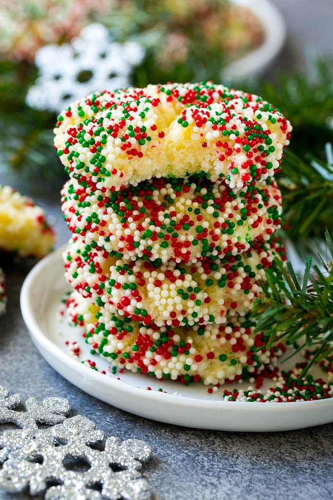 Gooey Butter Cookies Recipe | Cake Mix Cookies | Sprinkle Cookies | Christmas Cookies #cookies #butter #sprinkles #christmas #dessert #baking #jonep A stack of gooey butter cookies with a bite taken out of one.