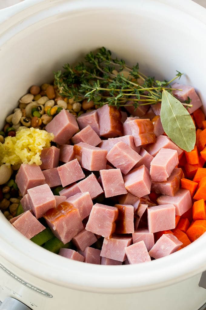Ham and Bean Soup Recipe | Slow Cooker Ham and Bean Soup | Crockpot Ham and Bean Soup | Leftover Ham Recipe #ham #beans #soup #slowcooker #crockpot #dinner #jonep Vegetables, pork, herbs and garlic in the slow cooker.