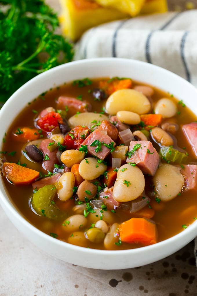 Ham and Bean Soup Recipe | Slow Cooker Ham and Bean Soup | Crockpot Ham and Bean Soup | Leftover Ham Recipe #ham #beans #soup #slowcooker #crockpot #dinner #jonep A bowl of ham and bean soup made with dried beans, ham and vegetables, then topped with fresh parsley.