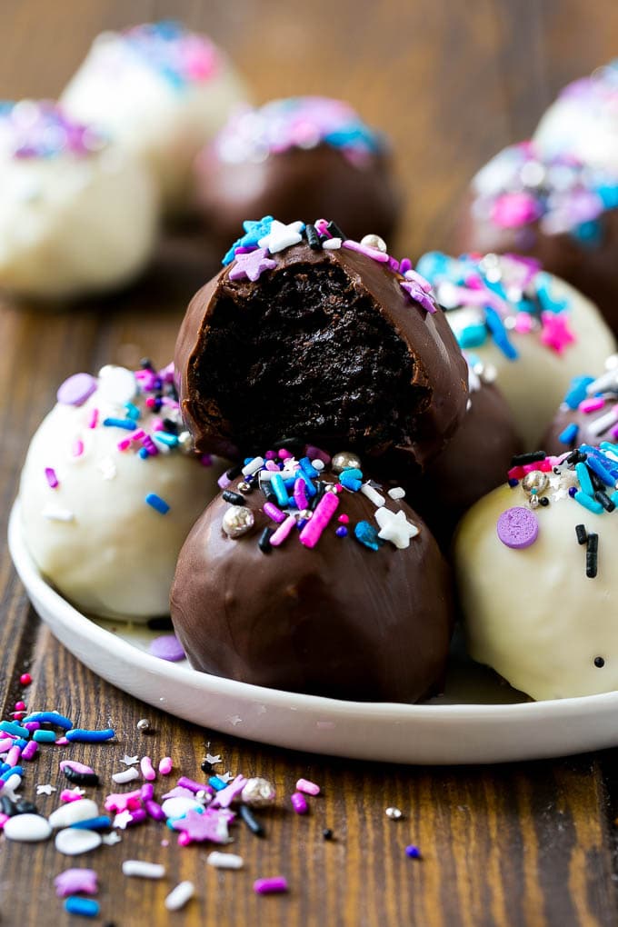 Oreo Balls Recipe | Oreo Truffles | Homemade Candy #truffles #candy #oreos #chocolate #sprinkles #dessert #christmas #jonep A plate of dark and white chocolate Oreo balls topped with colorful sprinkles.