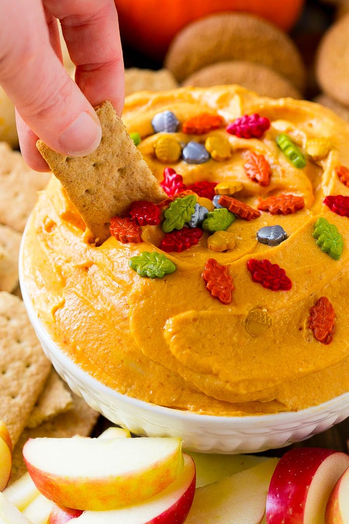 Pumpkin Dip Recipe | Dessert Dip | Pumpkin Pie Dip #pumpkin #dessert #dip #fall #thanksgiving #jonep A bowl of pumpkin dip with a graham cracker scooping some out.