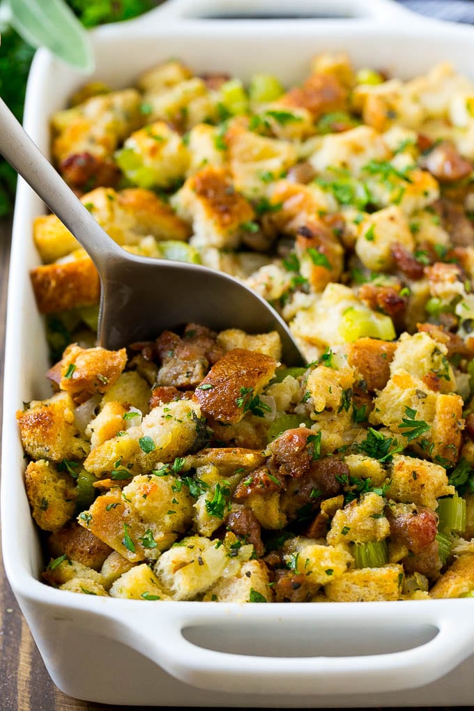 Sausage Stuffing Recipe | Thanksgiving Stuffing | Make Ahead Stuffing #stuffing #thanksgiving #sausage #sidedish #dinner #jonep A baking dish of sausage stuffing with a serving spoon in it.