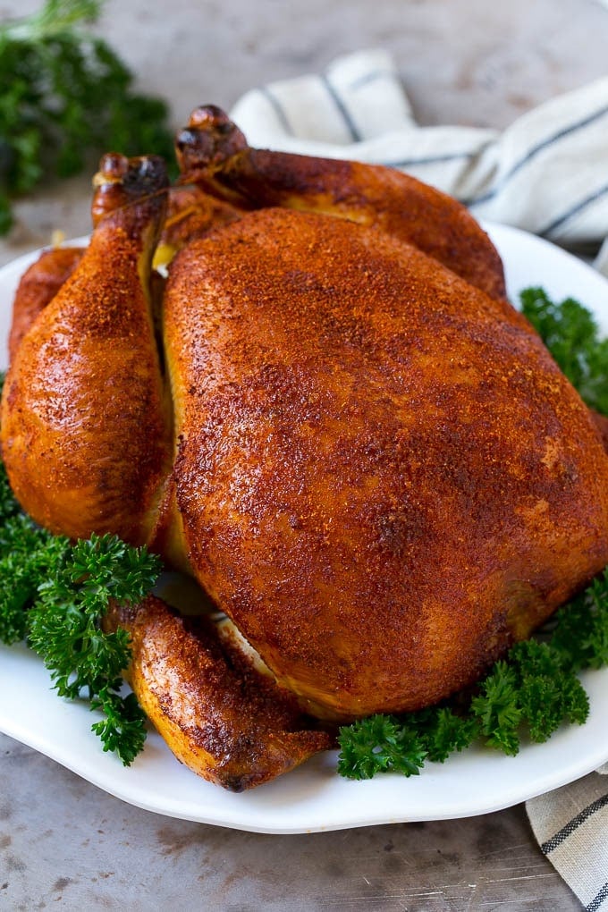 Smoked Chicken Recipe | Whole Smoked Chicken | BBQ Chicken #chicken #smoker #BBQ #dinner #jonep #glutenfree #lowcarb Smoked chicken on a serving platter garnished with parsley.