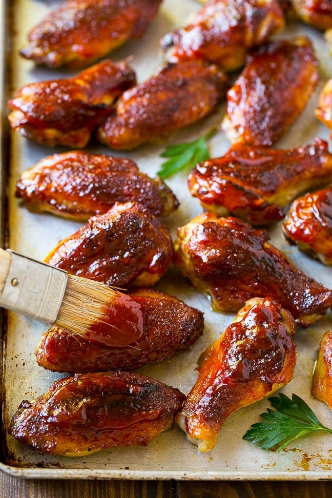 Smoked Chicken Wings | Barbecue Chicken Wings | BBQ Chicken Wings #chicken #wings #bbq #barbecue #appetizer #dinner #jonep BBQ sauce brushed onto a sheet pan of smoked chicken wings.