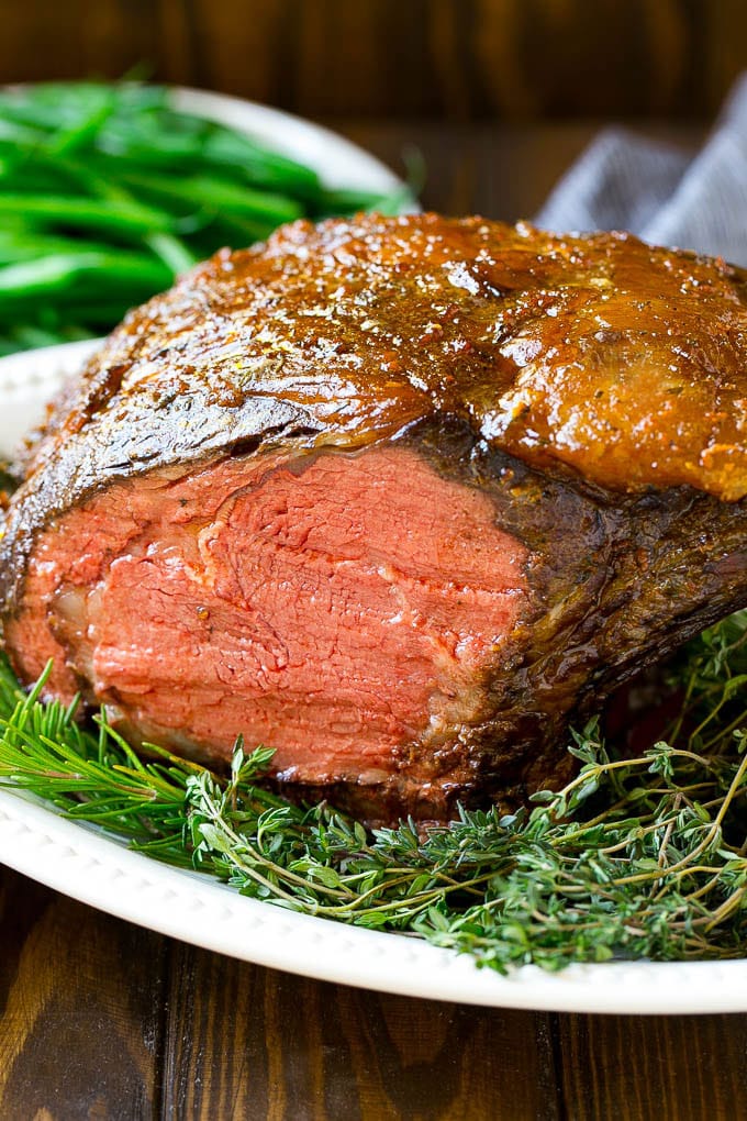 Smoked Prime Rib Recipe | Easy Prime Rib | Smoked Beef | Holiday Prime Rib #primerib #beef #smoker #dinner #jonep #christmas #thanksgiving #lowcarb #keto A smoked prime rib roast cooked to medium rare on a serving platter.