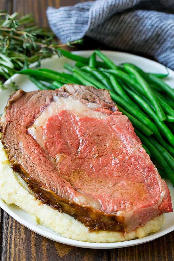 Smoked Prime Rib Recipe | Easy Prime Rib | Smoked Beef | Holiday Prime Rib #primerib #beef #smoker #dinner #jonep #christmas #thanksgiving #lowcarb #keto A slice of prime rib over mashed potatoes with green beans on the side.