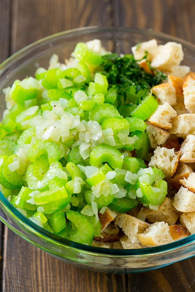 Turkey Stuffing Recipe | Thanksgiving Stuffing | Classic Stuffing #thanksgiving #stuffing #sidedish #fall #jonep Bread cubes, celery, onion and herbs in a mixing bowl.