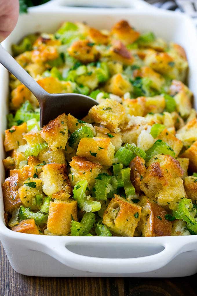 Turkey Stuffing Recipe | Thanksgiving Stuffing | Classic Stuffing #thanksgiving #stuffing #sidedish #fall #jonep Turkey stuffing in a casserole dish with a serving spoon in it.